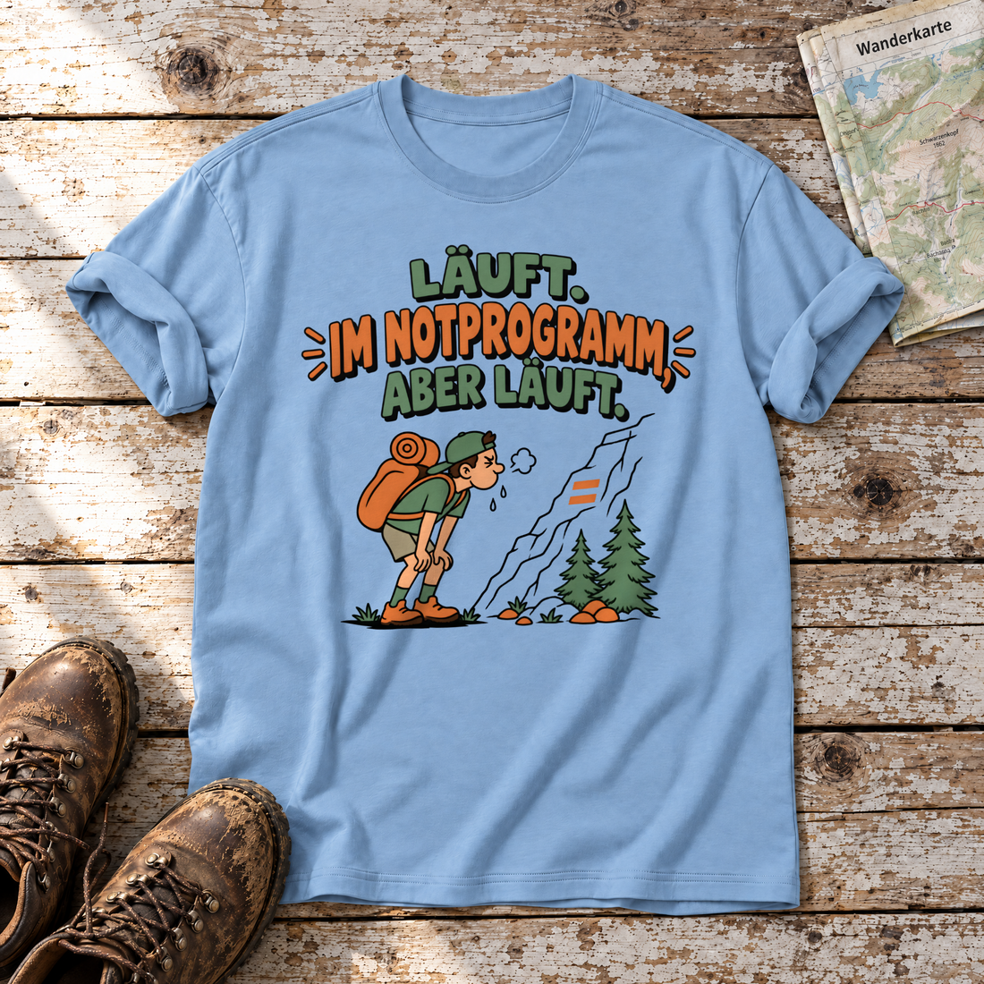 Im Notprogramm, aber läuft – T-Shirt Unisex in Himmelblau, flach liegend auf alten Holzbrettern mit Wanderschuhen und Wanderkarte.