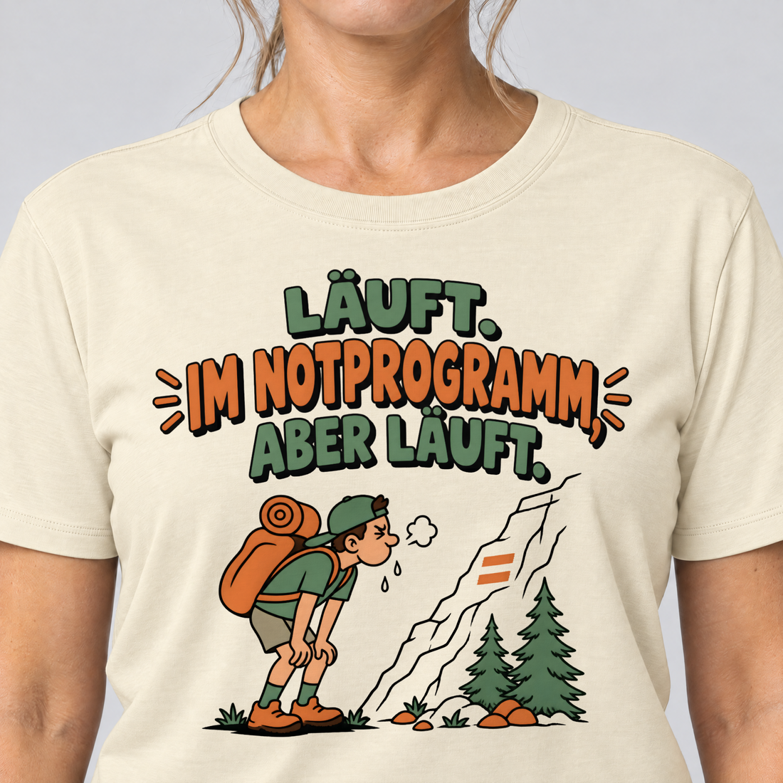 Nahaufnahme des Drucks: Im Notprogramm, aber läuft – T-Shirt Unisex in Natur, von einer Frau getragen