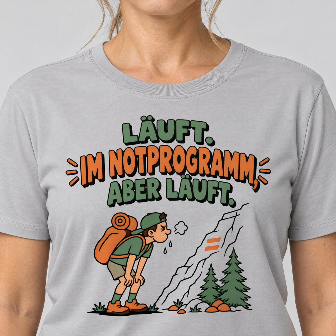 Nahaufnahme des Drucks: Im Notprogramm, aber läuft – T-Shirt Unisex in Hellgrau, von einer Frau getragen