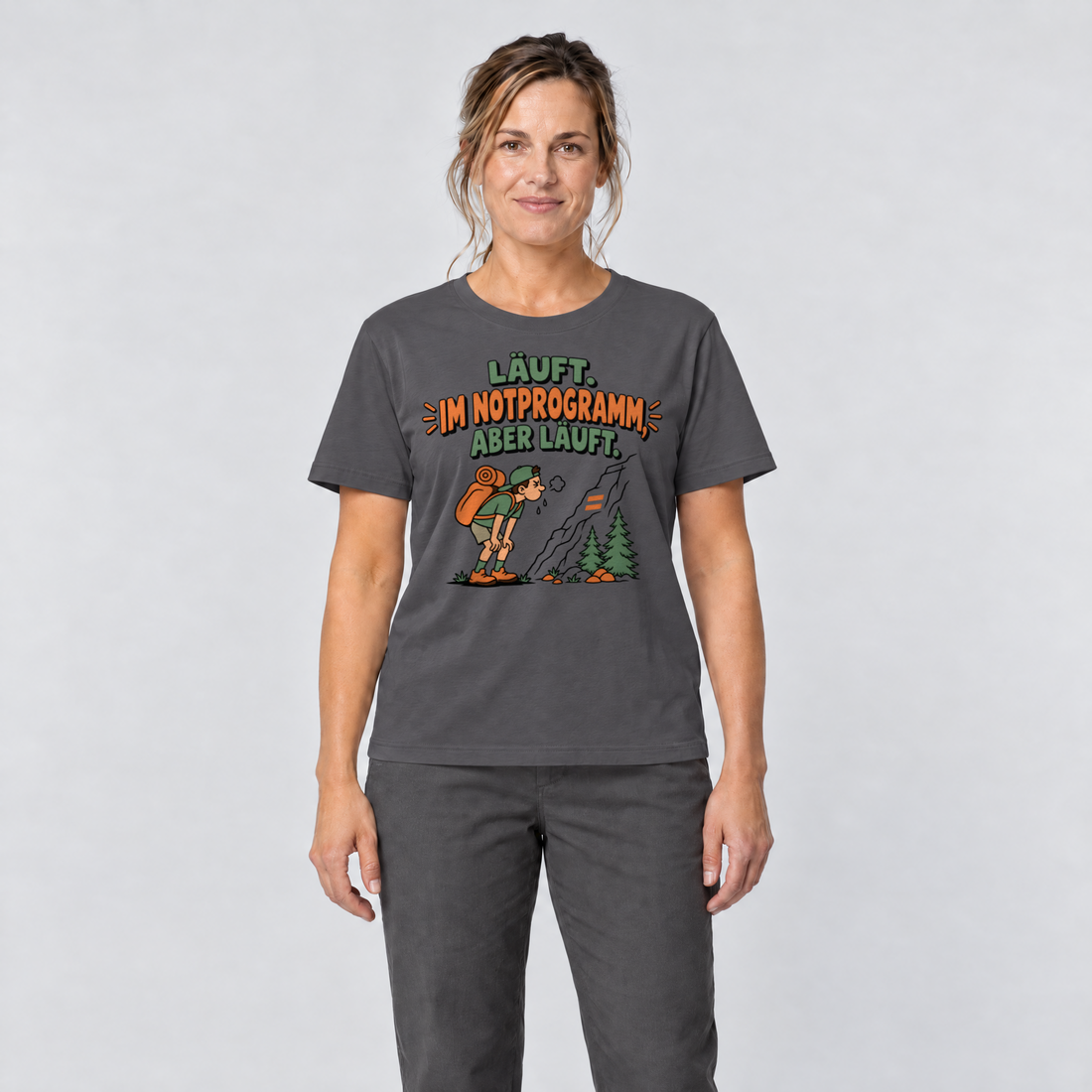 Frau trägt Im Notprogramm, aber läuft – T-Shirt Unisex in Dunkelgrau, Ansicht von vorn