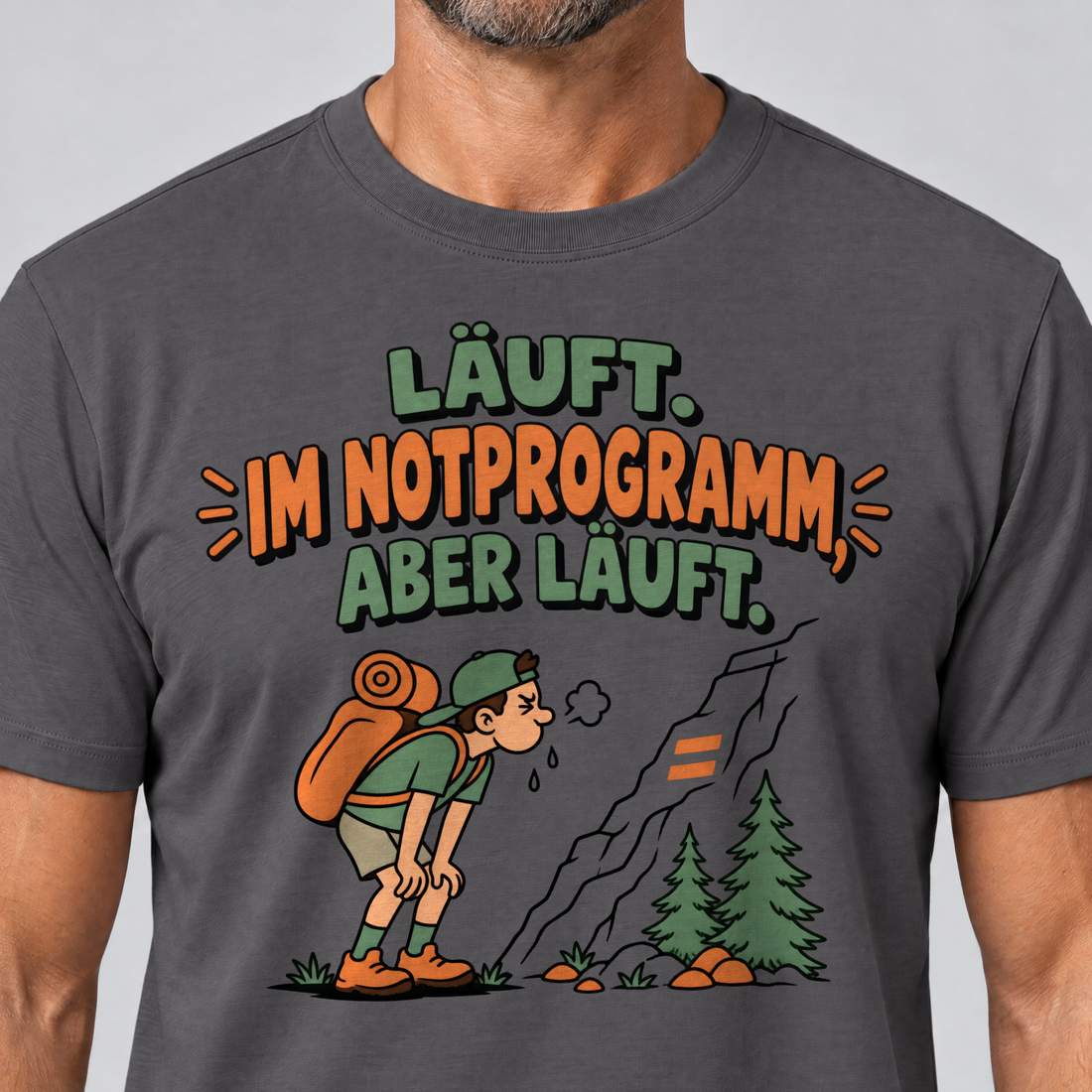Nahaufnahme des Drucks: Im Notprogramm, aber läuft – T-Shirt Unisex in Dunkelgrau, von einem Mann getragen