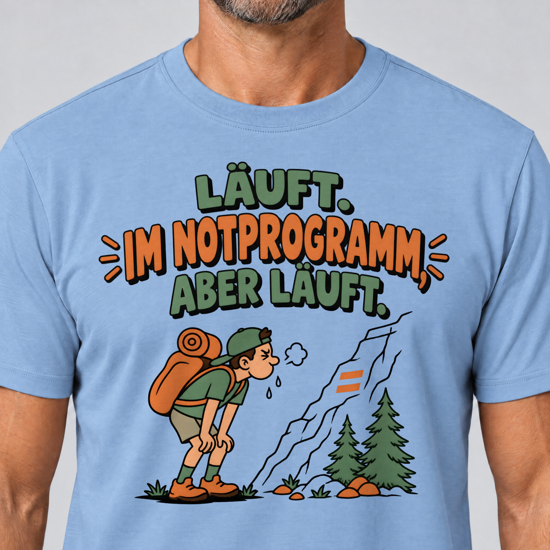 Nahaufnahme des Drucks: Im Notprogramm, aber läuft – T-Shirt Unisex in Himmelblau, von einem Mann getragen