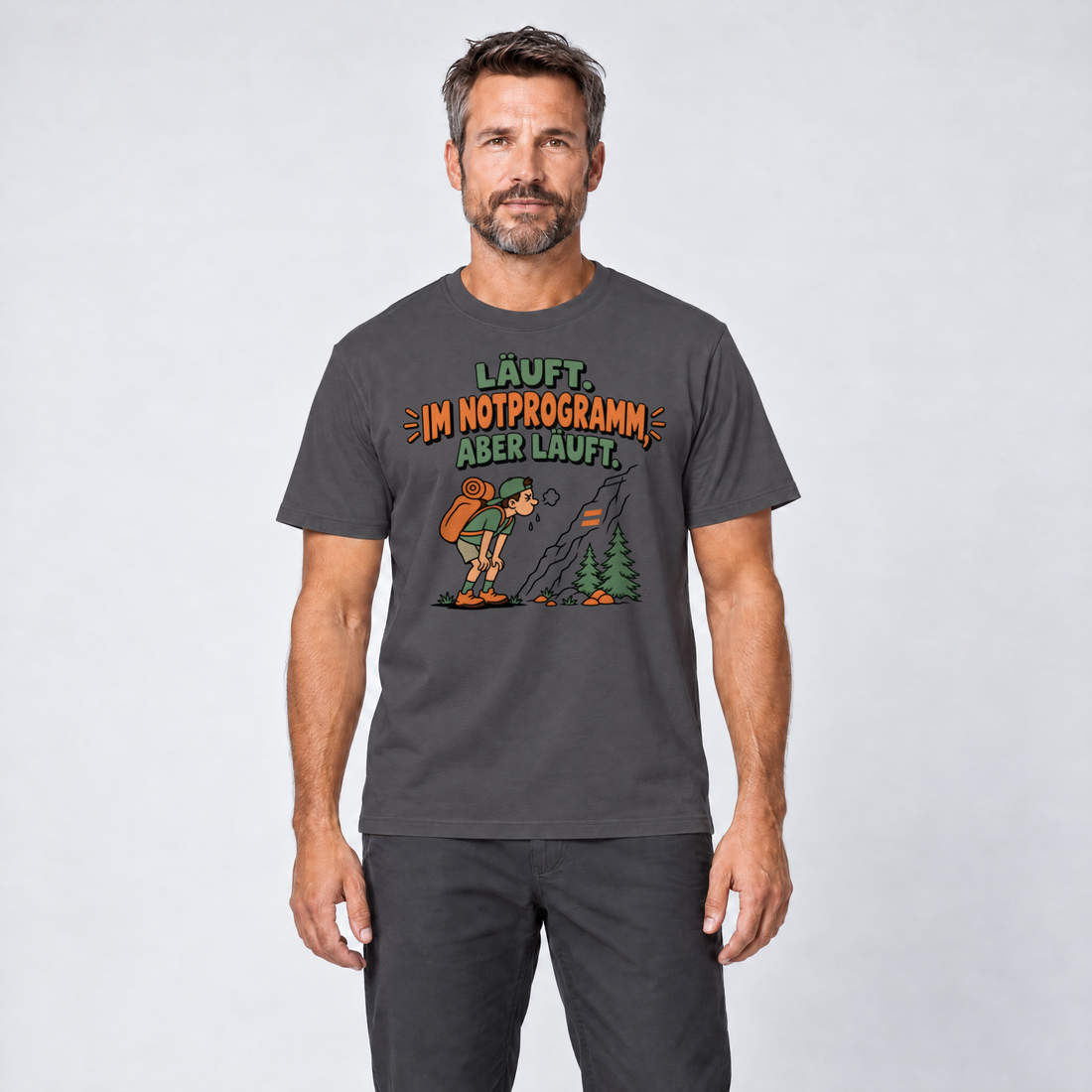 Mann trägt Im Notprogramm, aber läuft – T-Shirt Unisex in Dunkelgrau, Ansicht von vorn
