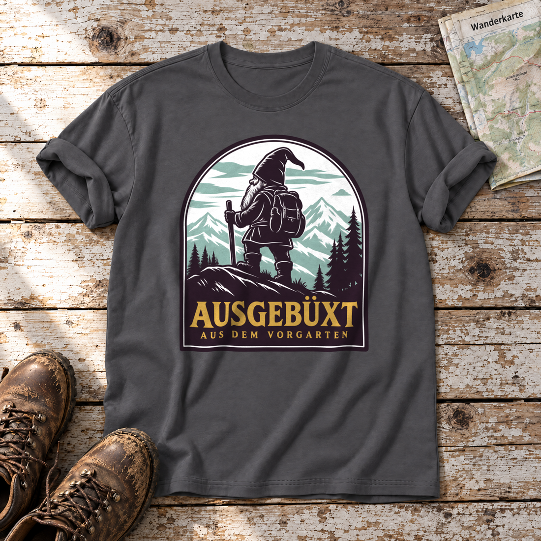 Ausgebüxt aus dem Vorgarten – T-Shirt Unisex in Dunkelgrau, flach liegend auf alten Holzbrettern mit Wanderschuhen und Wanderkarte.