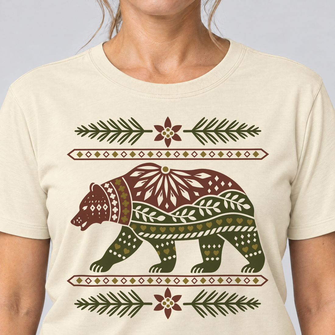 Nahaufnahme des Drucks: Bär im Alpenornament – T-Shirt Unisex in Natur, von einer Frau getragen