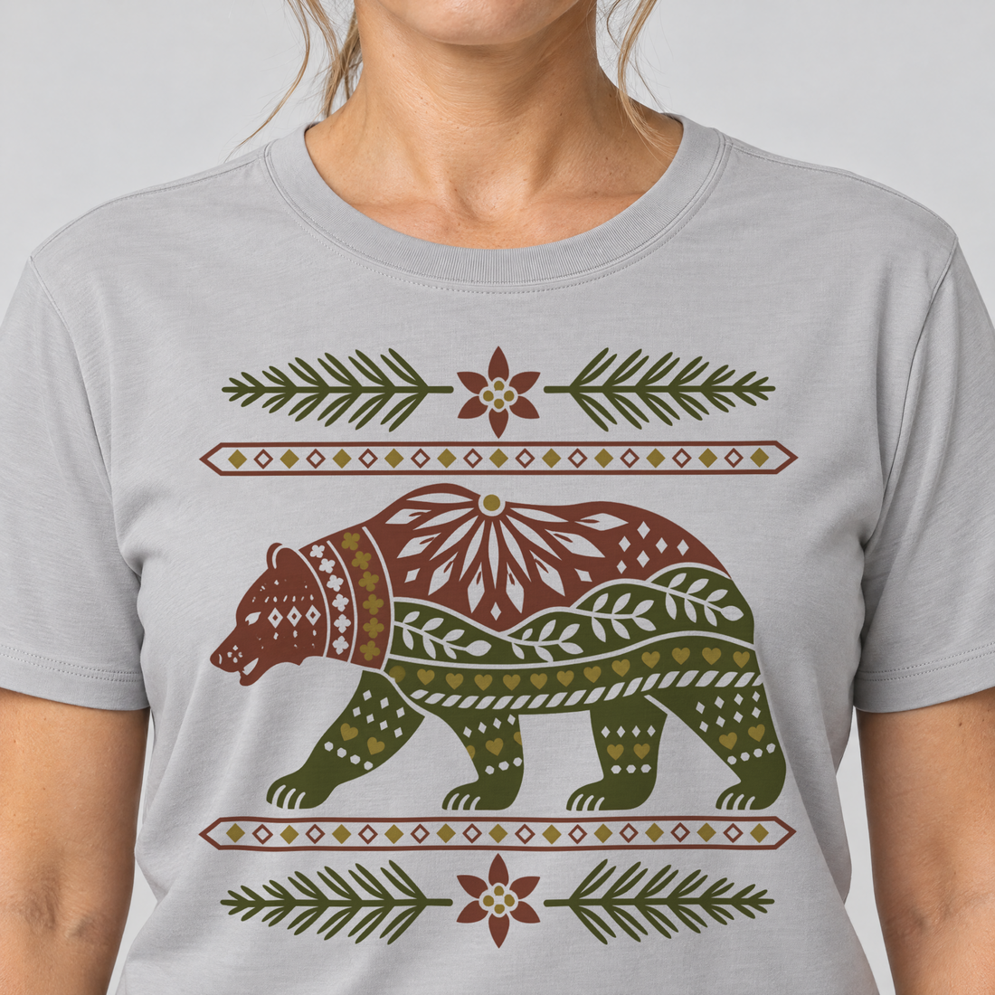Nahaufnahme des Drucks: Bär im Alpenornament – T-Shirt Unisex in Hellgrau, von einer Frau getragen