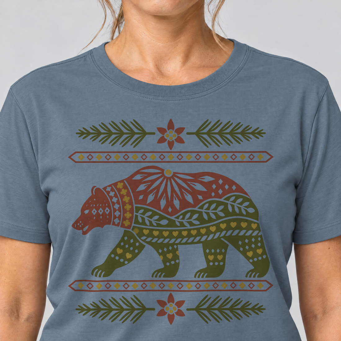 Nahaufnahme des Drucks: Bär im Alpenornament – T-Shirt Unisex in Steinblau, von einer Frau getragen