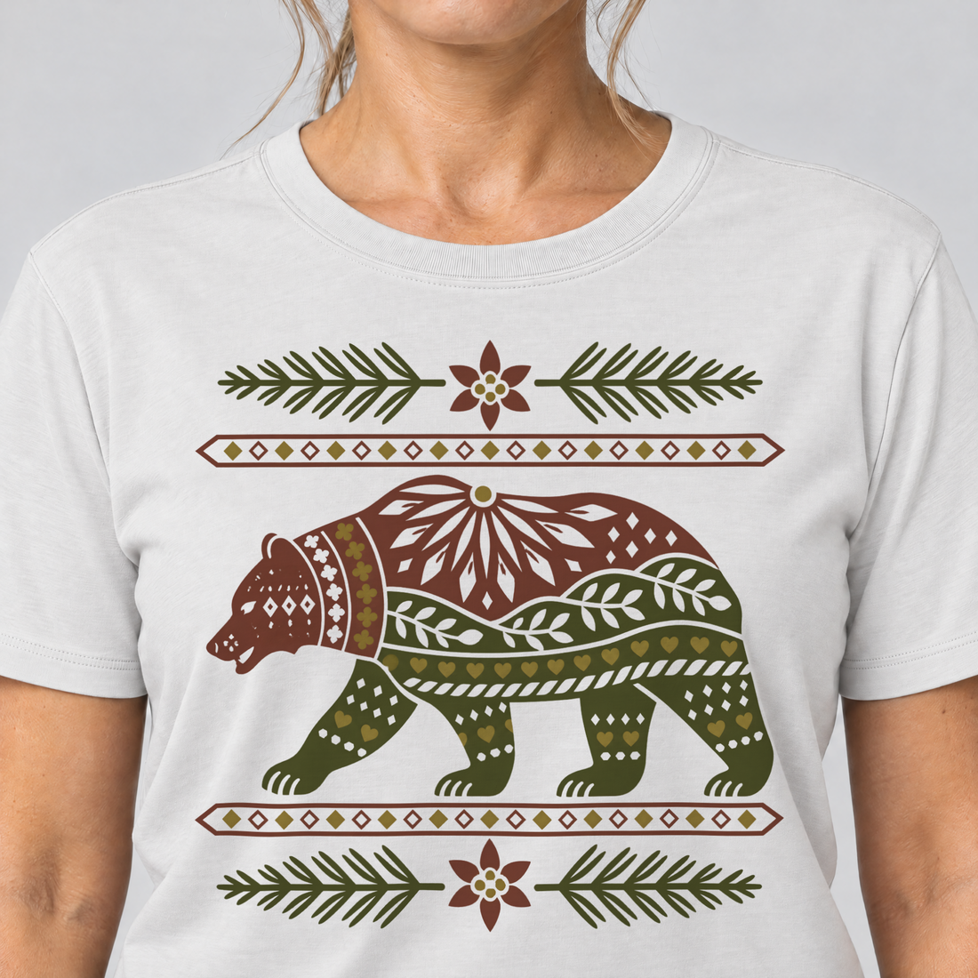 Nahaufnahme des Drucks: Bär im Alpenornament – T-Shirt Unisex in Weiß, von einer Frau getragen