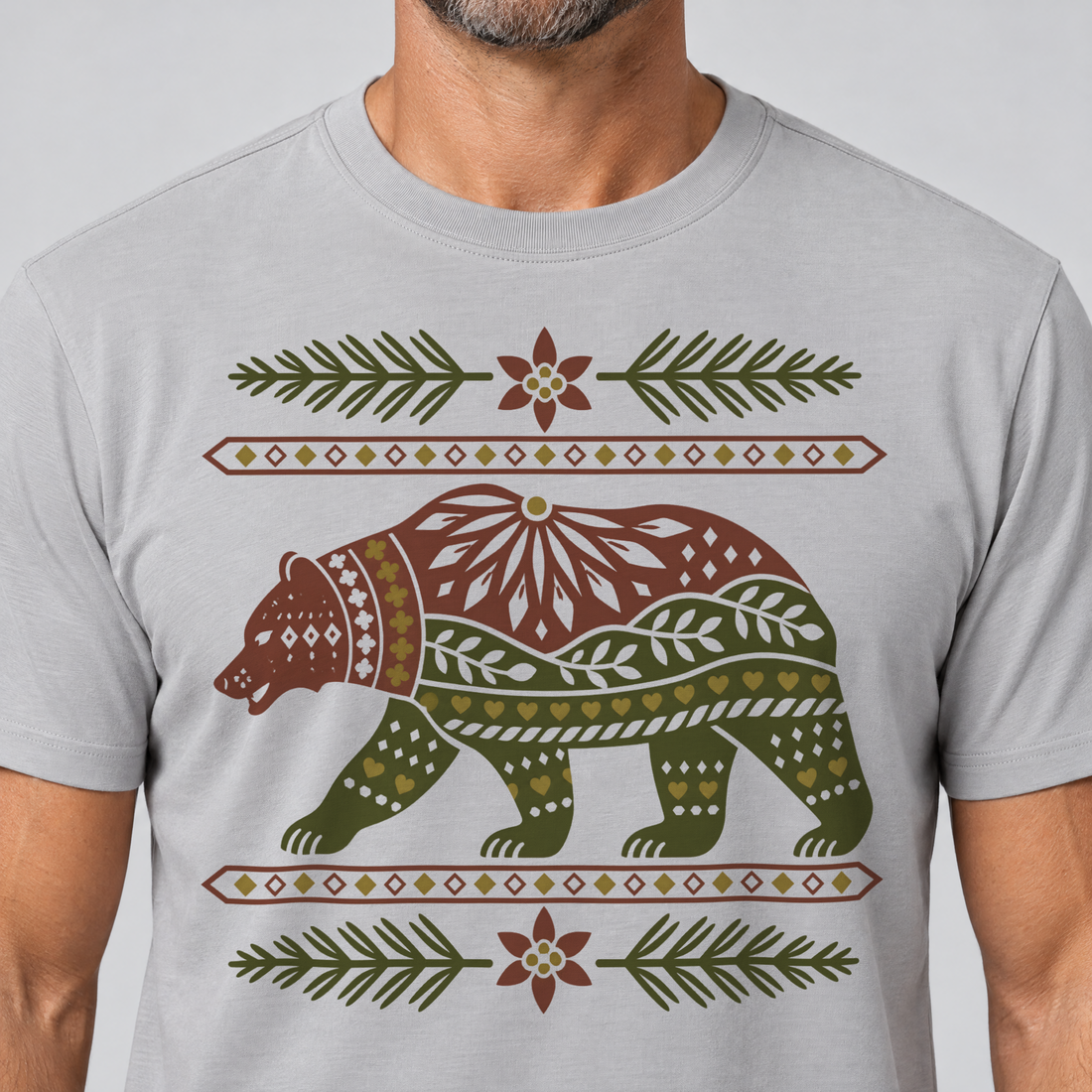 Nahaufnahme des Drucks: Bär im Alpenornament – T-Shirt Unisex in Hellgrau, von einem Mann getragen