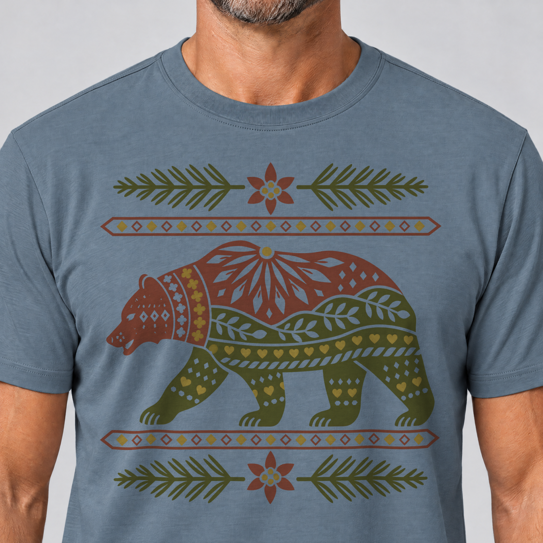 Nahaufnahme des Drucks: Bär im Alpenornament – T-Shirt Unisex in Steinblau, von einem Mann getragen