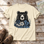 Bär in der Alpenwiese – T-Shirt Unisex in Natur, flach liegend auf alten Holzbrettern mit Wanderschuhen und Wanderkarte.
