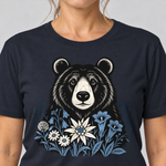 Nahaufnahme des Drucks: Bär in der Alpenwiese – T-Shirt Unisex in Navy, von einer Frau getragen