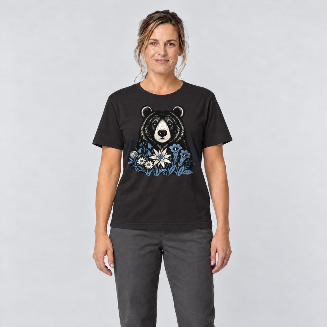 Frau trägt Bär in der Alpenwiese – T-Shirt Unisex in Schwarz, Ansicht von vorn