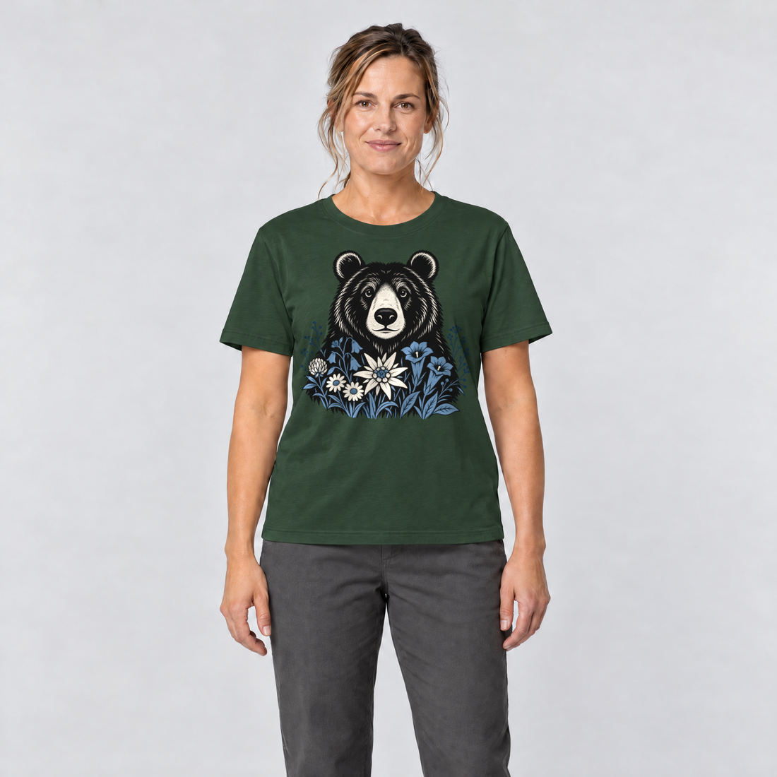 Frau trägt Bär in der Alpenwiese – T-Shirt Unisex in Flaschengrün, Ansicht von vorn