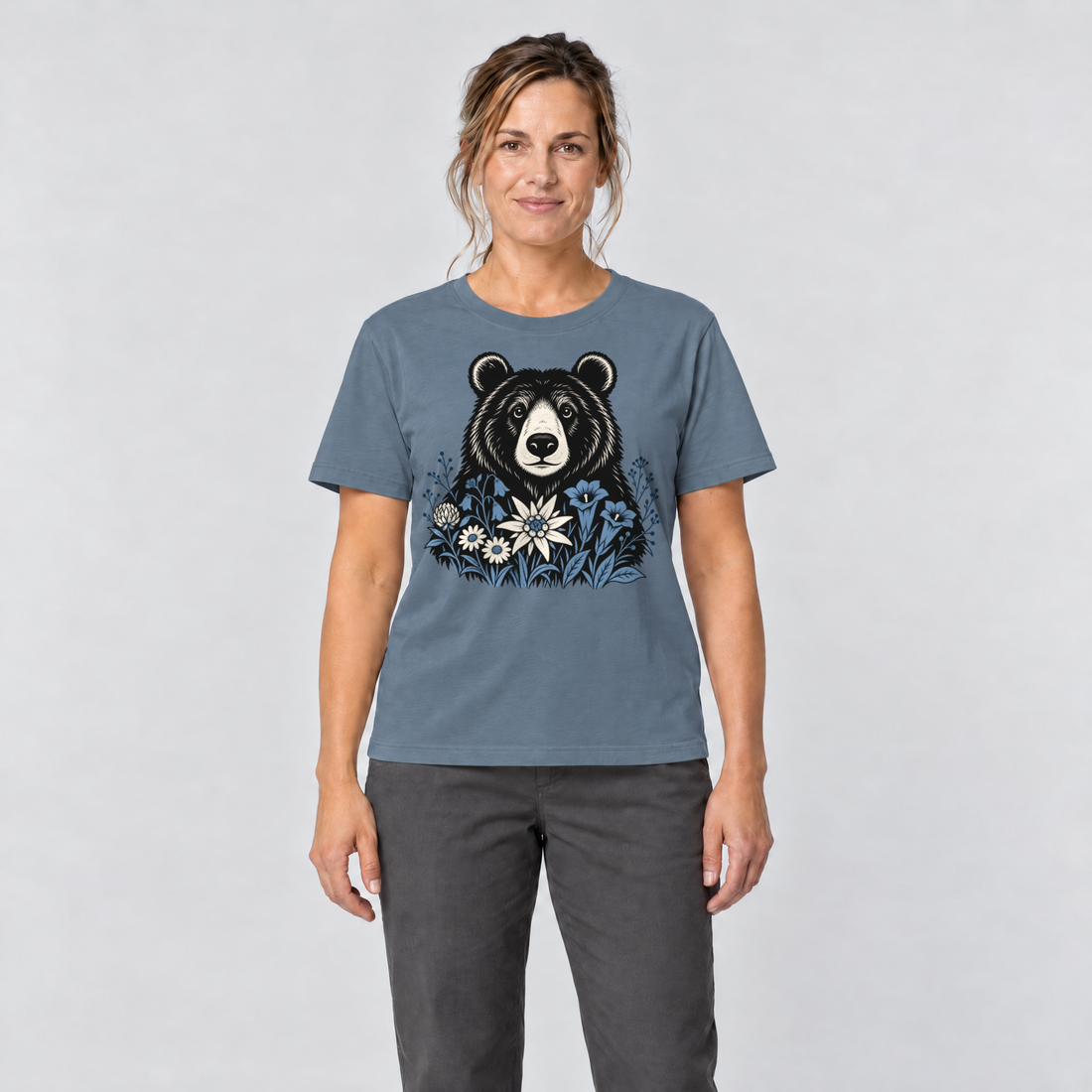 Frau trägt Bär in der Alpenwiese – T-Shirt Unisex in Steinblau, Ansicht von vorn