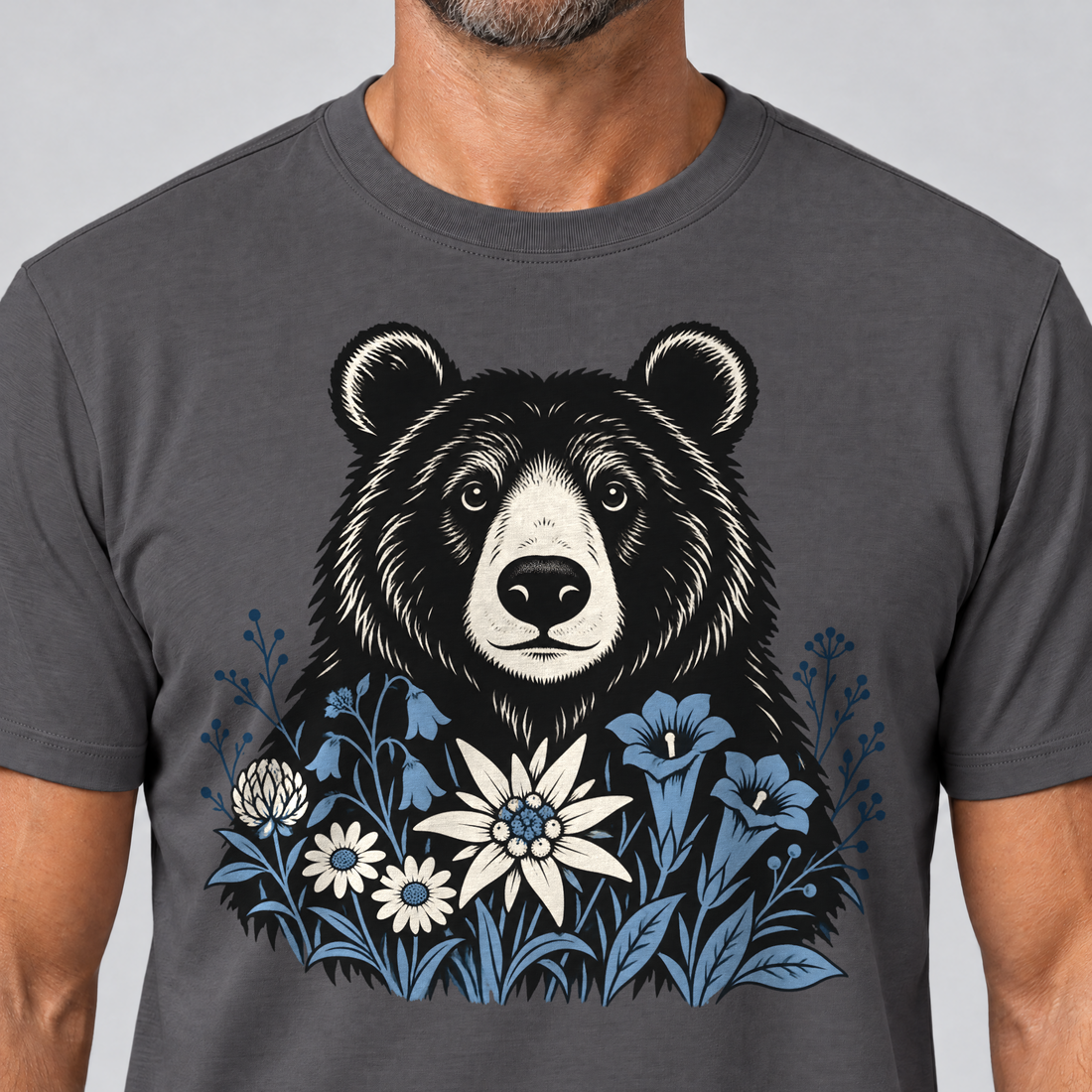 Nahaufnahme des Drucks: Bär in der Alpenwiese – T-Shirt Unisex in Dunkelgrau, von einem Mann getragen