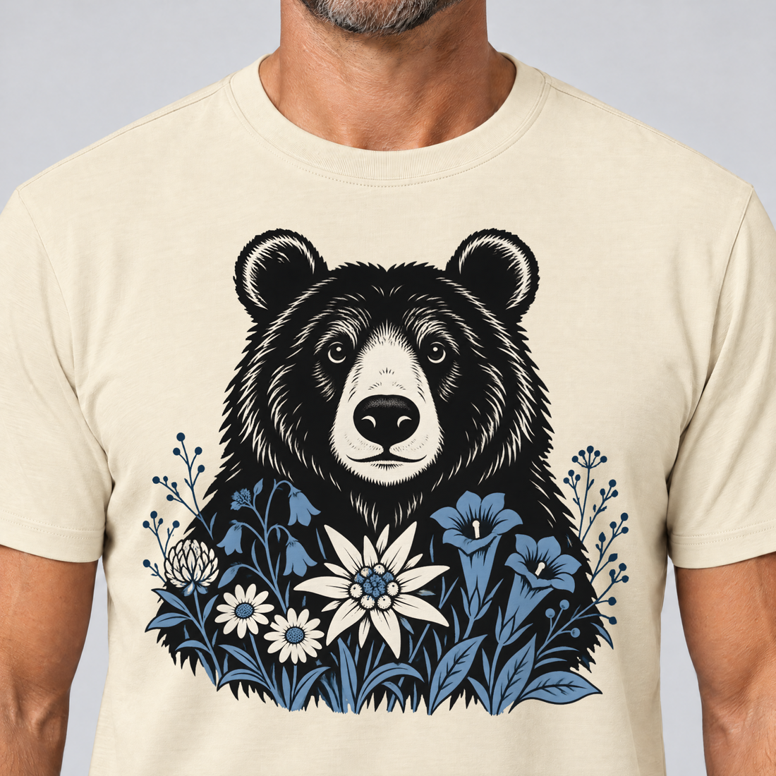 Nahaufnahme des Drucks: Bär in der Alpenwiese – T-Shirt Unisex in Natur, von einem Mann getragen