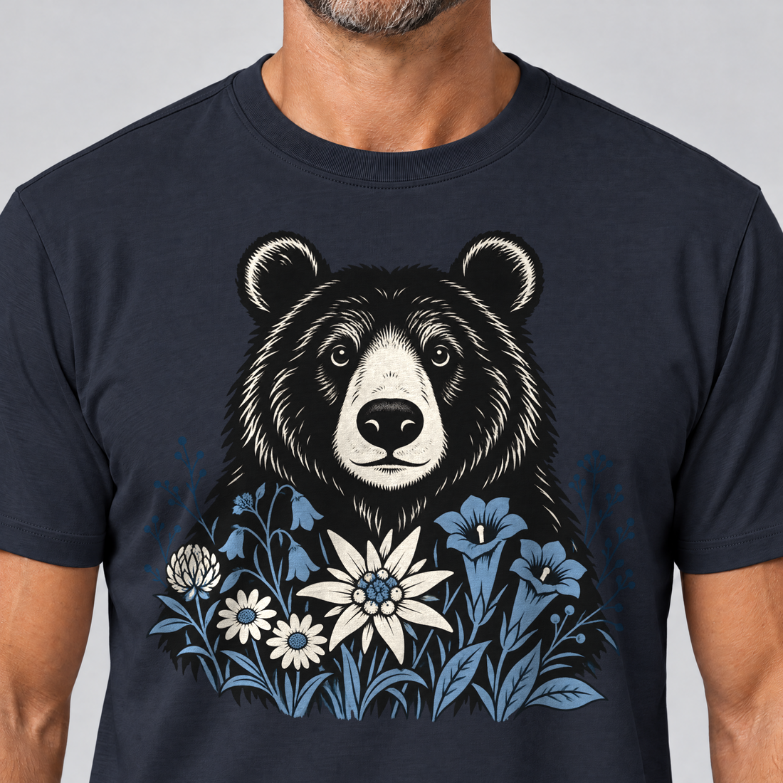 Nahaufnahme des Drucks: Bär in der Alpenwiese – T-Shirt Unisex in Navy, von einem Mann getragen