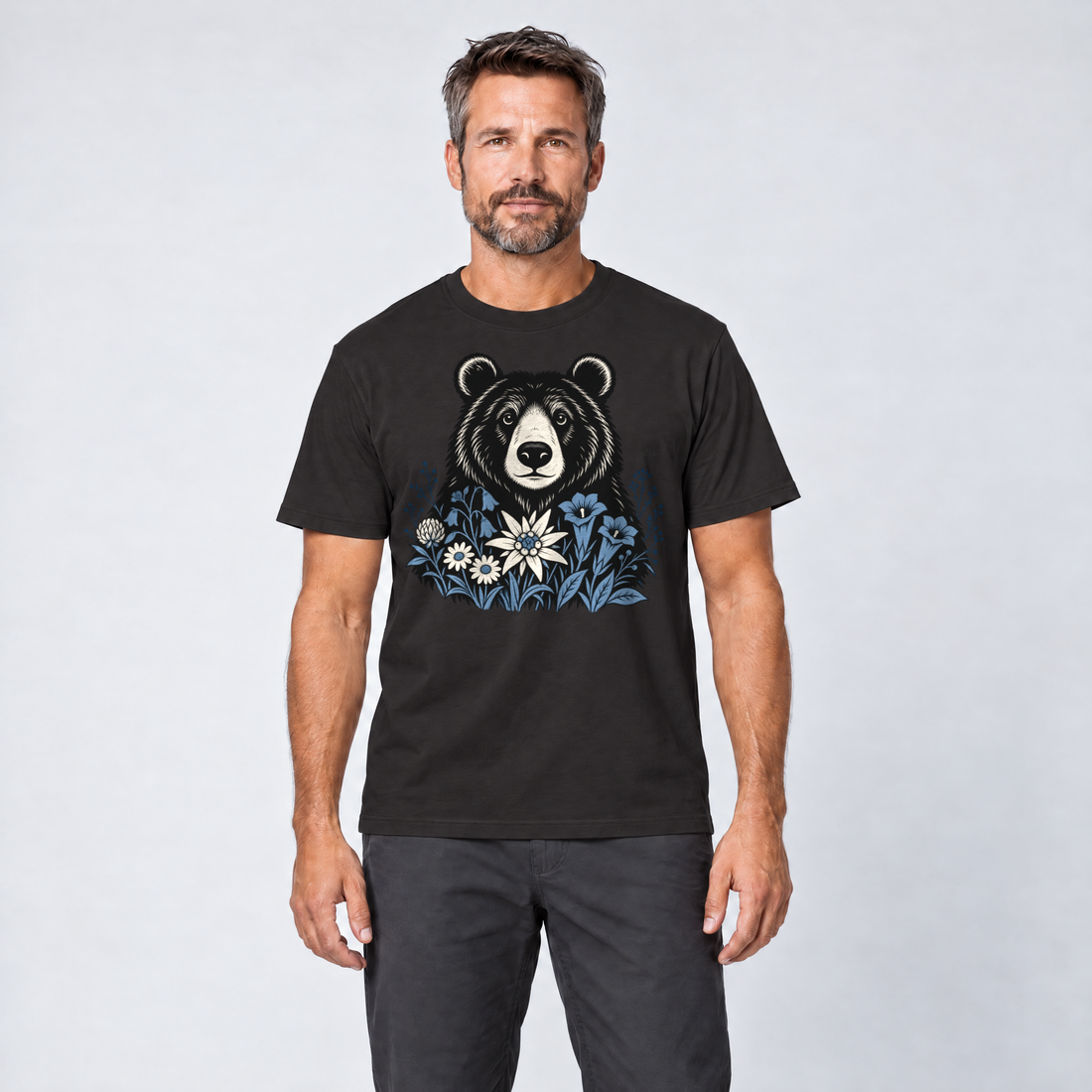 Mann trägt Bär in der Alpenwiese – T-Shirt Unisex in Schwarz, Ansicht von vorn