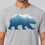 Nahaufnahme des Drucks: Bär im Bergwald – T-Shirt Unisex in Hellgrau, von einem Mann getragen