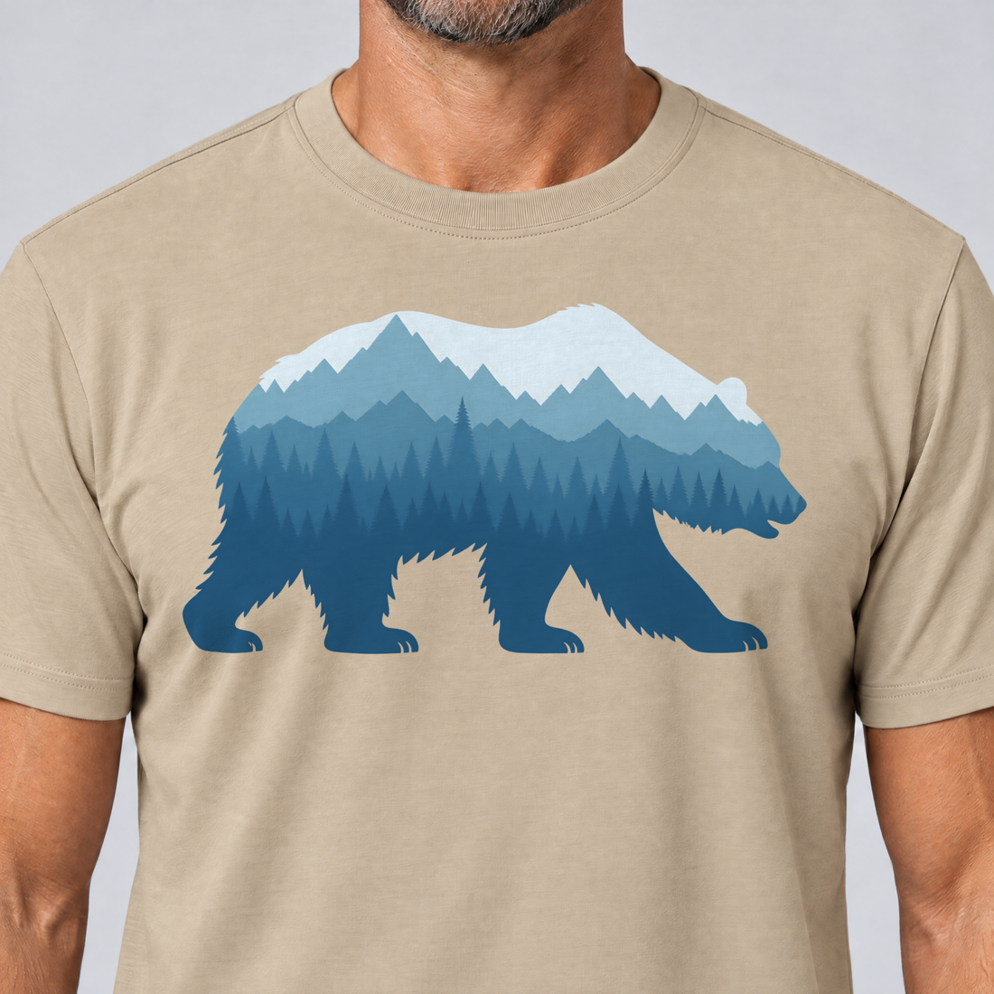 Nahaufnahme des Drucks: Bär im Bergwald – T-Shirt Unisex in Sand, von einem Mann getragen