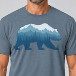 Nahaufnahme des Drucks: Bär im Bergwald – T-Shirt Unisex in Steinblau, von einem Mann getragen