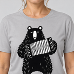 Nahaufnahme des Drucks: Bär mit Steirischer – T-Shirt Unisex in Hellgrau, von einer Frau getragen