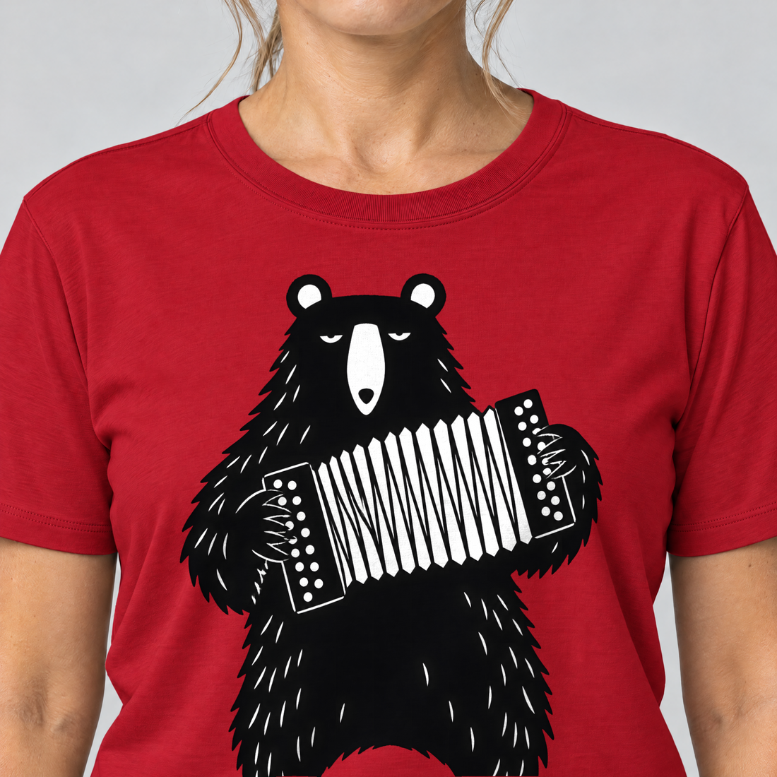 Nahaufnahme des Drucks: Bär mit Steirischer – T-Shirt Unisex in Rot, von einer Frau getragen