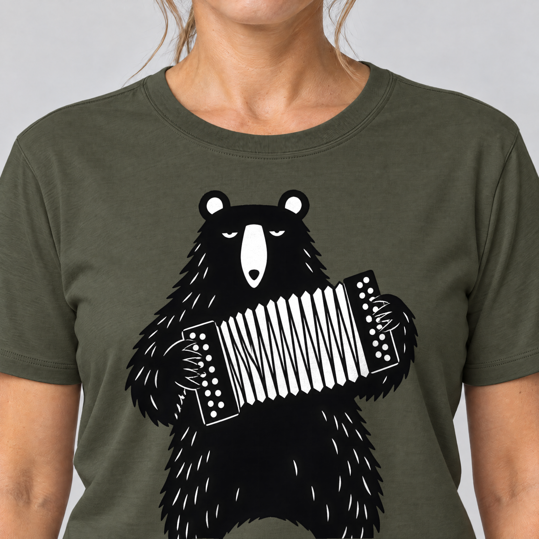 Nahaufnahme des Drucks: Bär mit Steirischer – T-Shirt Unisex in Oliv, von einer Frau getragen