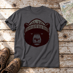 Bär mit Strickmütze – T-Shirt Unisex in Dunkelgrau, flach liegend auf alten Holzbrettern mit Wanderschuhen und Wanderkarte.