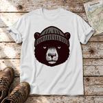Bär mit Strickmütze – T-Shirt Unisex in Weiß, flach liegend auf alten Holzbrettern mit Wanderschuhen und Wanderkarte.
