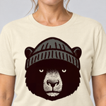 Nahaufnahme des Drucks: Bär mit Strickmütze – T-Shirt Unisex in Natur, von einer Frau getragen
