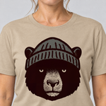 Nahaufnahme des Drucks: Bär mit Strickmütze – T-Shirt Unisex in Sand, von einer Frau getragen