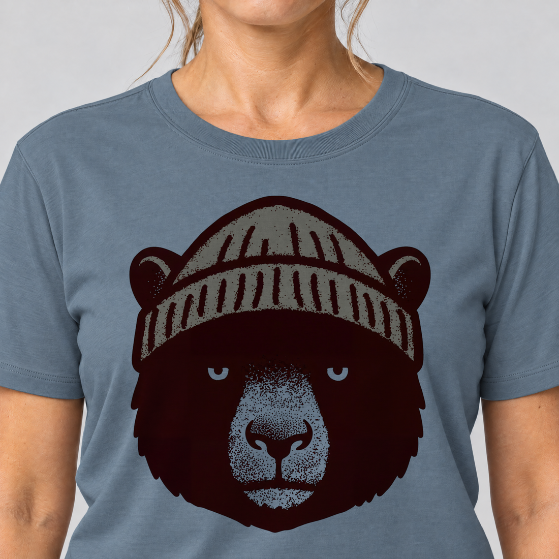 Nahaufnahme des Drucks: Bär mit Strickmütze – T-Shirt Unisex in Steinblau, von einer Frau getragen