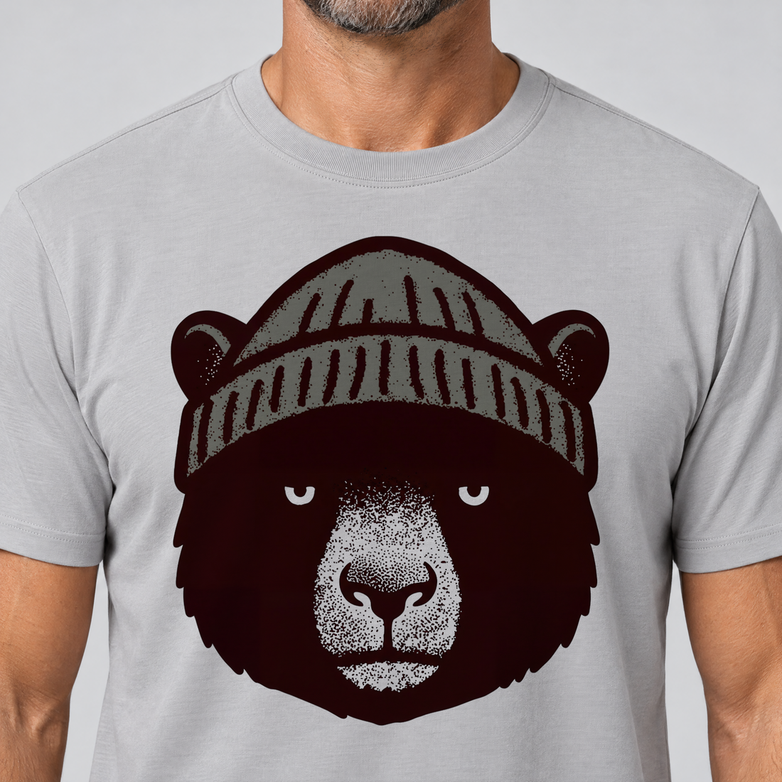 Nahaufnahme des Drucks: Bär mit Strickmütze – T-Shirt Unisex in Hellgrau, von einem Mann getragen