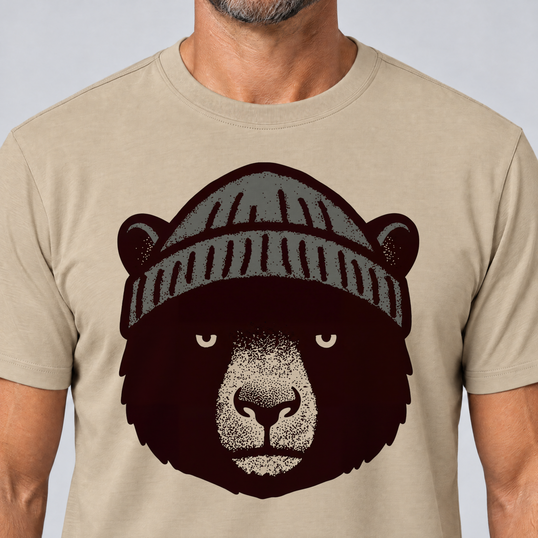 Nahaufnahme des Drucks: Bär mit Strickmütze – T-Shirt Unisex in Sand, von einem Mann getragen
