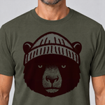 Nahaufnahme des Drucks: Bär mit Strickmütze – T-Shirt Unisex in Oliv, von einem Mann getragen