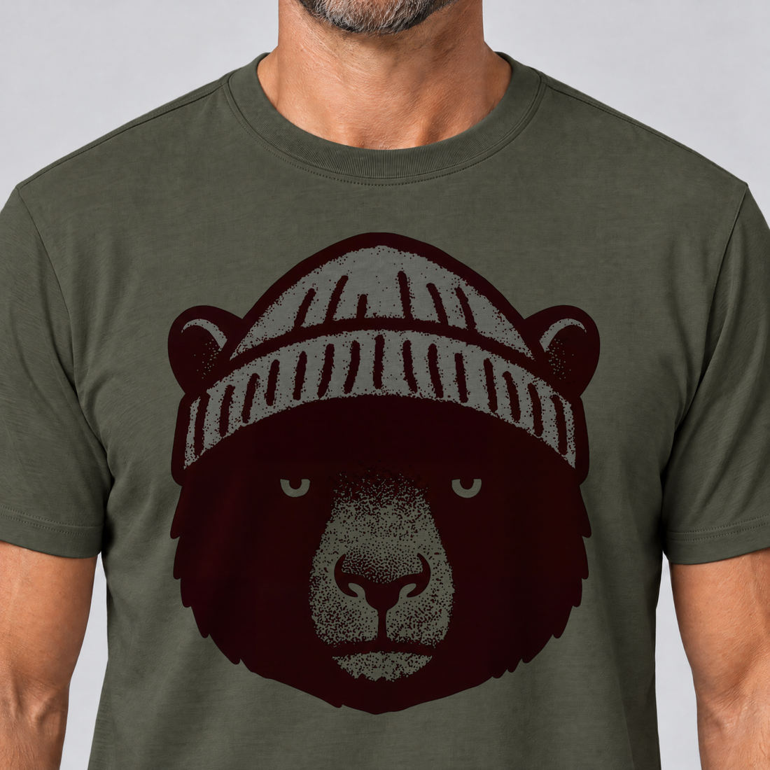 Nahaufnahme des Drucks: Bär mit Strickmütze – T-Shirt Unisex in Oliv, von einem Mann getragen