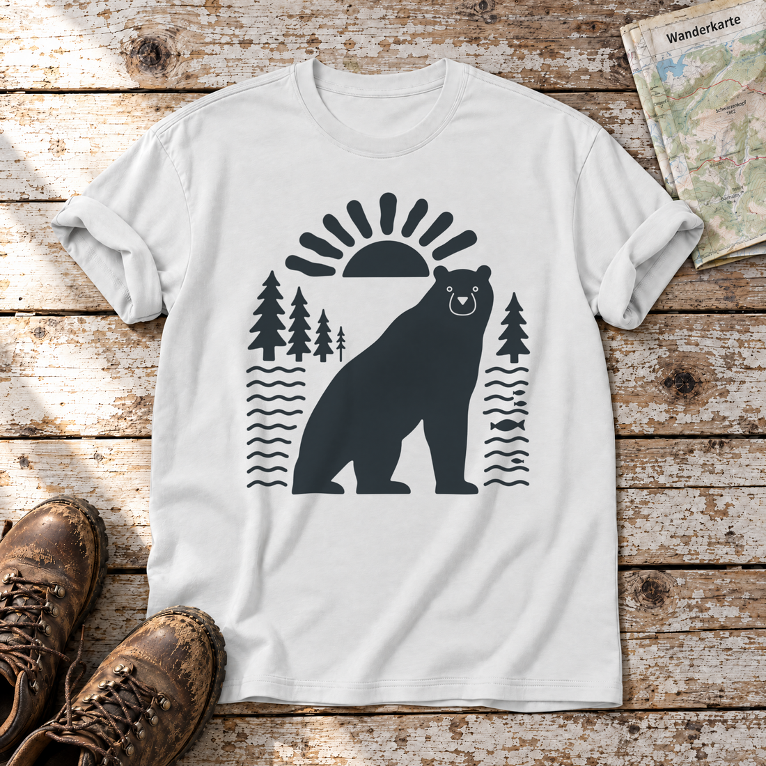 Bär im Sonnenbogen – T-Shirt Unisex in Weiß, flach liegend auf alten Holzbrettern mit Wanderschuhen und Wanderkarte.