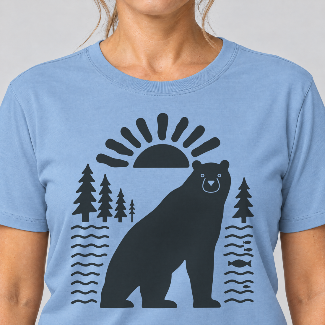 Nahaufnahme des Drucks: Bär im Sonnenbogen – T-Shirt Unisex in Himmelblau, von einer Frau getragen