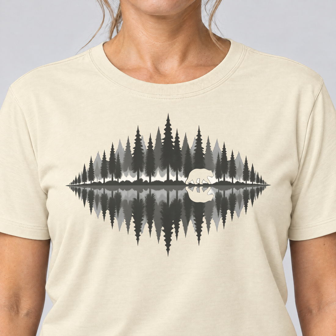 Nahaufnahme des Drucks: Bär am Waldsee – T-Shirt Unisex in Natur, von einer Frau getragen