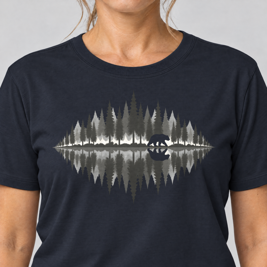 Nahaufnahme des Drucks: Bär am Waldsee – T-Shirt Unisex in Navy, von einer Frau getragen