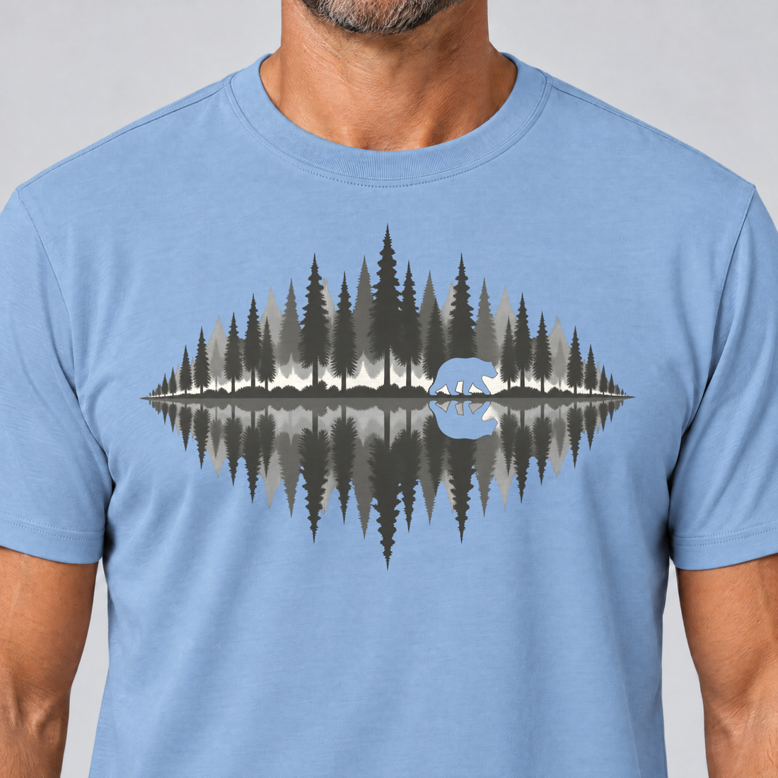 Nahaufnahme des Drucks: Bär am Waldsee – T-Shirt Unisex in Himmelblau, von einem Mann getragen