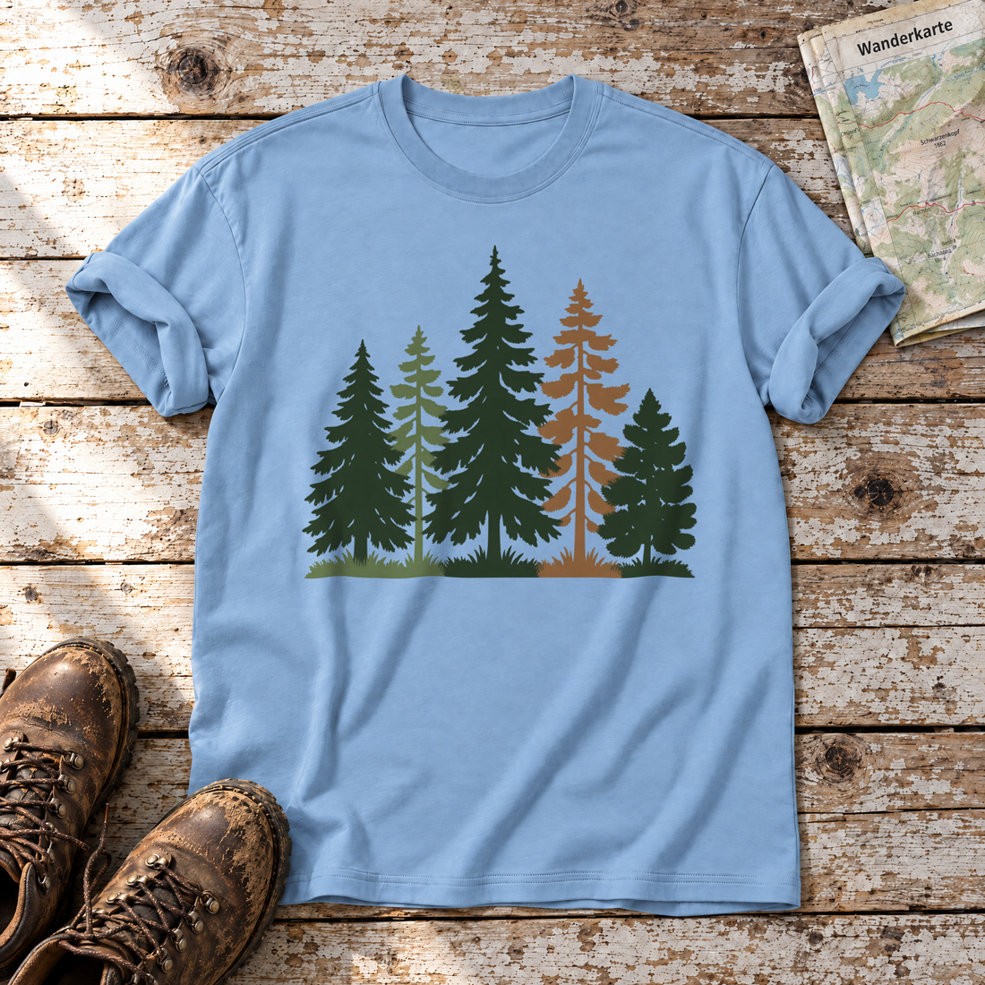Waldrand – T-Shirt Unisex in Himmelblau, flach liegend auf alten Holzbrettern mit Wanderschuhen und Wanderkarte.