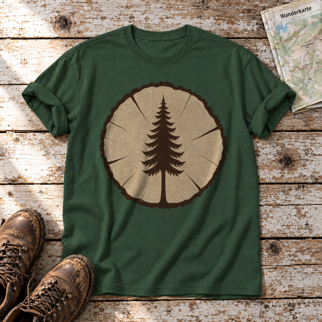 Fichte in der Baumscheibe – T-Shirt Unisex in Flaschengrün, flach liegend auf alten Holzbrettern mit Wanderschuhen und Wanderkarte.