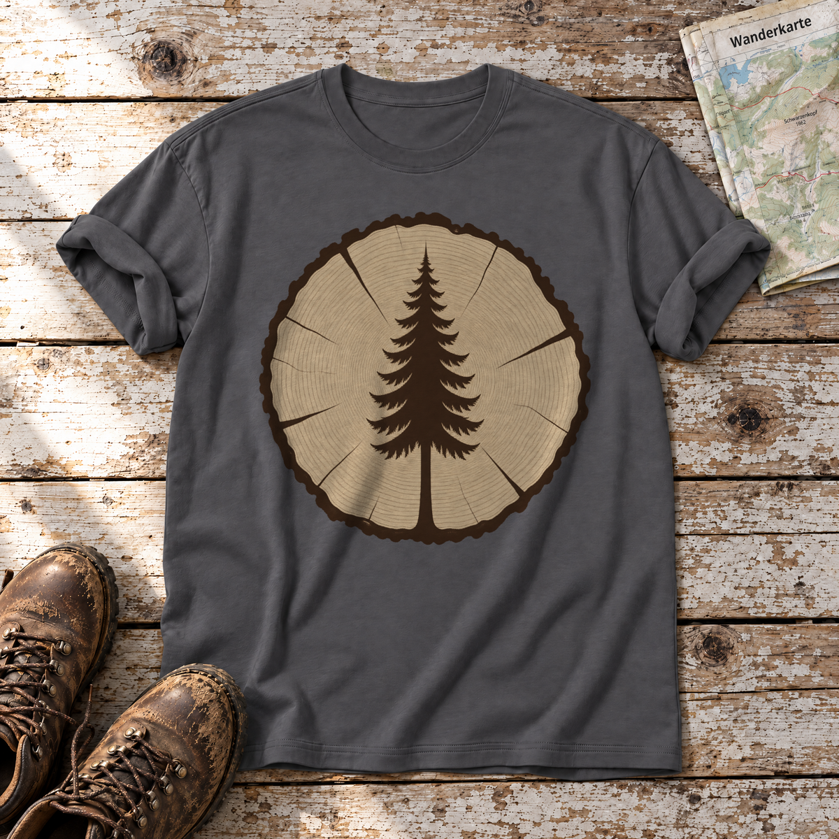 Fichte in der Baumscheibe – T-Shirt Unisex in Dunkelgrau, flach liegend auf alten Holzbrettern mit Wanderschuhen und Wanderkarte.