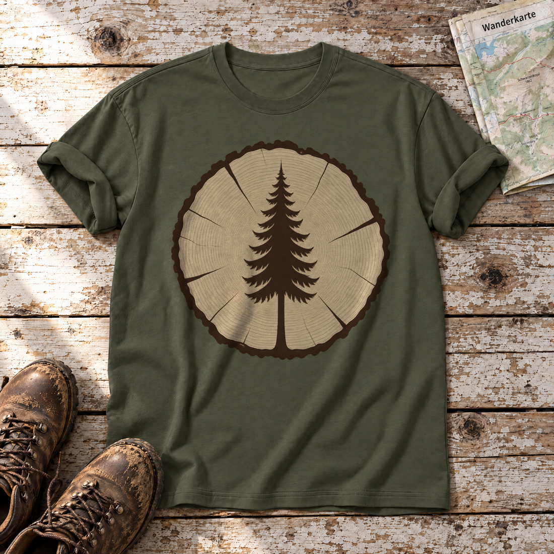 Fichte in der Baumscheibe – T-Shirt Unisex in Oliv, flach liegend auf alten Holzbrettern mit Wanderschuhen und Wanderkarte.