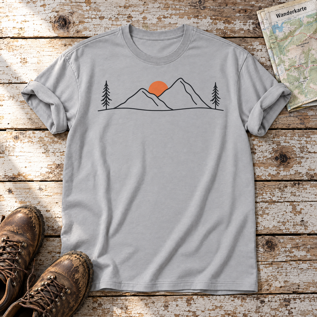 Abendsonne in den Bergen – T-Shirt Unisex in Hellgrau, flach liegend auf alten Holzbrettern mit Wanderschuhen und Wanderkarte.