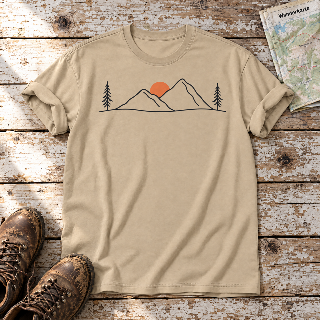 Abendsonne in den Bergen – T-Shirt Unisex in Sand, flach liegend auf alten Holzbrettern mit Wanderschuhen und Wanderkarte.