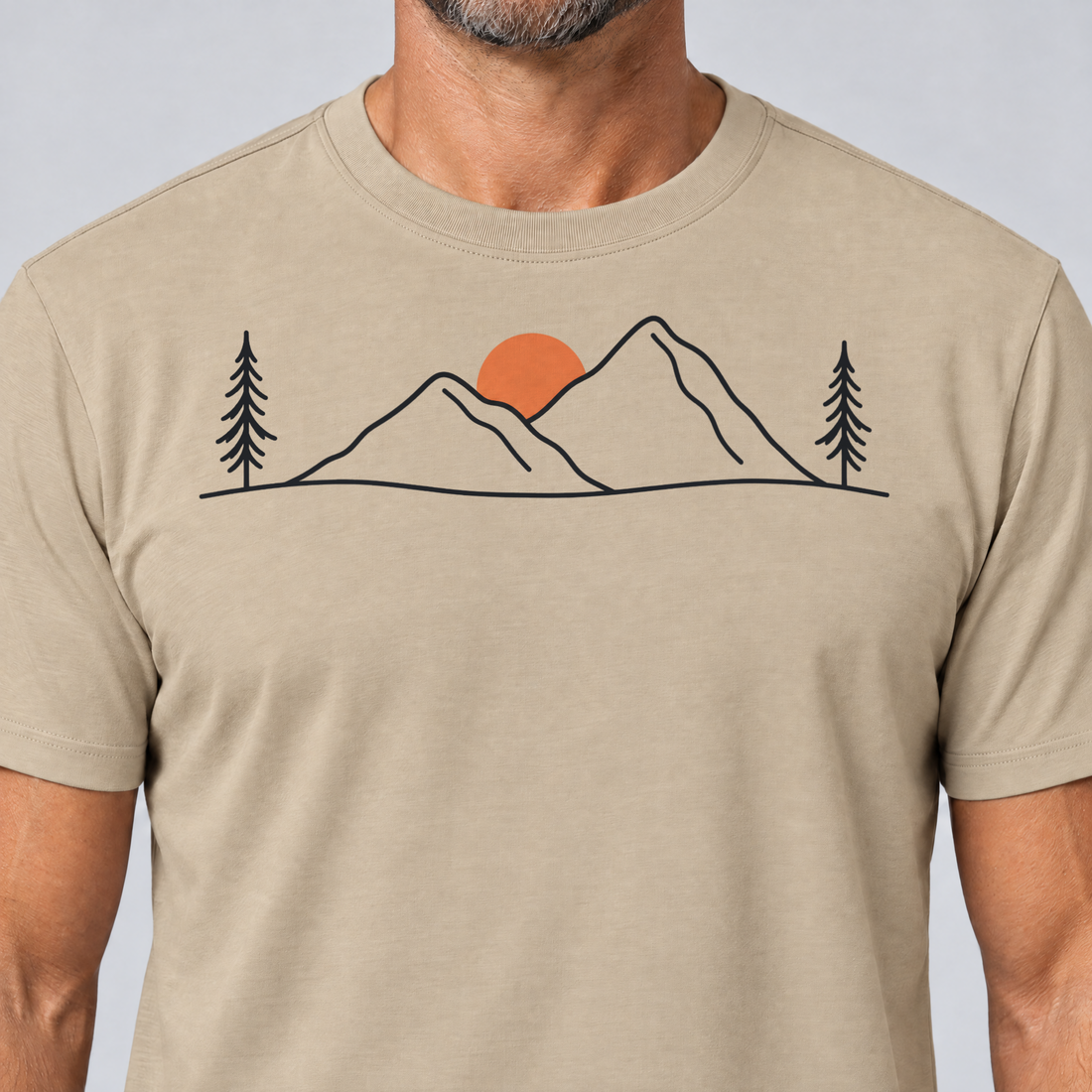 Nahaufnahme des Drucks: Abendsonne in den Bergen – T-Shirt Unisex in Sand, von einem Mann getragen